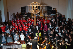 Musiker und Schülerchor befinden sich im Altarraum einer Kirche