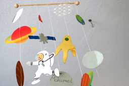 ein selbst gebasteltes Mobile mit Astronaut und Planeten hängt von der Decke.
