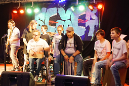 Acht junge Musiker musizieren auf einer Bühne.