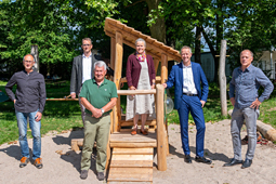 Sechs Personen am neuen Spielhaus im Garten des Schulkindergartens.