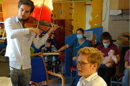 Ein Pianist und ein Geiger spielen für die Bewohner der Sozialpädagogischen Wohngemeinschaften Karlsruhe.