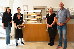 Das Team von Tonis Hofcafé vor einer Kuchentheke.