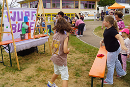 Gut besucht: Die Spielstraße mit vielen Mitmach-Stationen kommt besonders bei den kleinen Gästen gut an. Im Bild zu sehen ist eine Wurfbude und Kinder, die Bälle werfen.